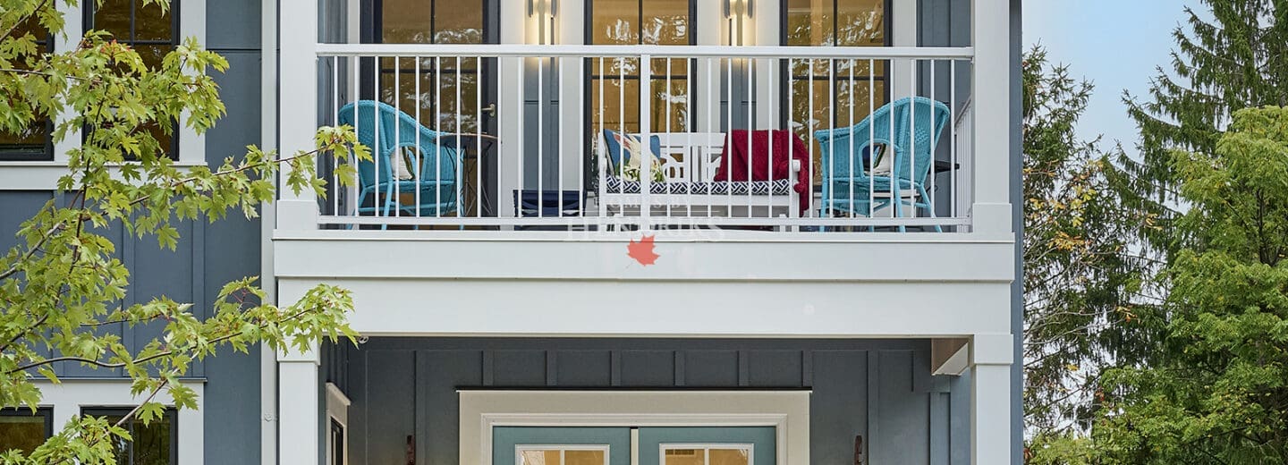 Exterior view of a coastal house in Niagara-on-the-Lake, featuring a charming balcony and boards and batten siding.