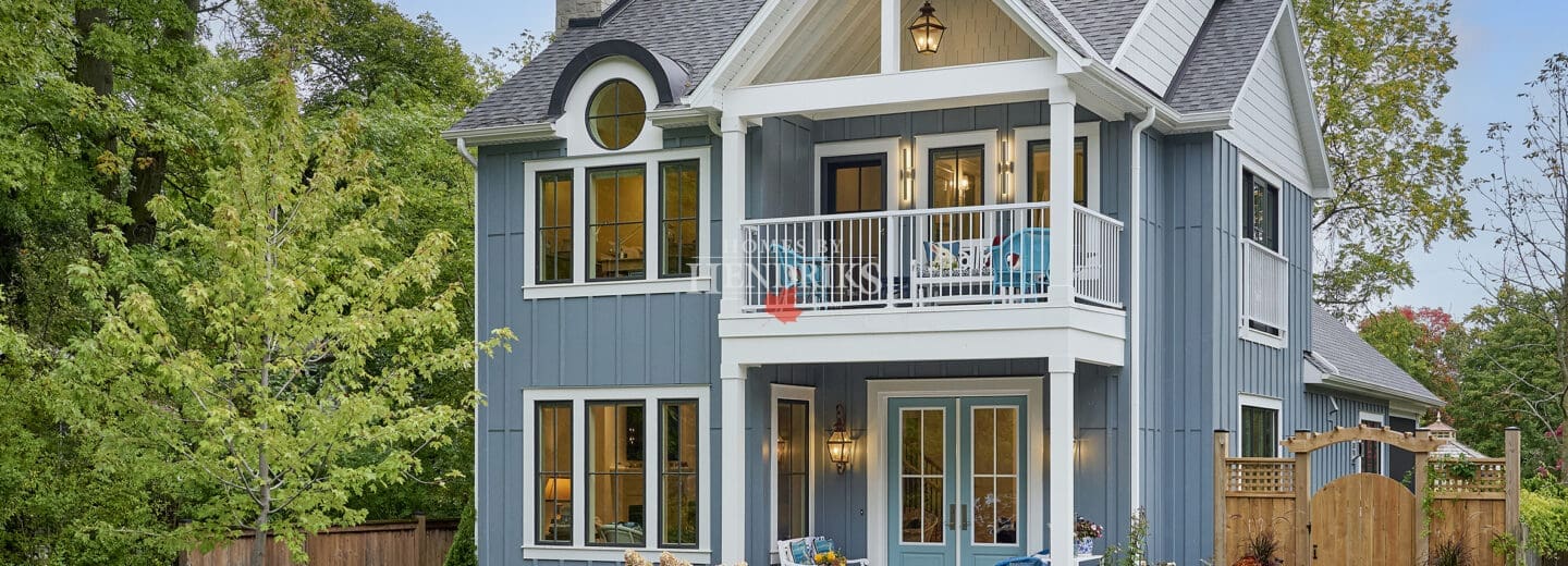 Exterior view of a coastal house in Niagara-on-the-Lake, showcasing a corner angle with a balcony and boards and batten siding.