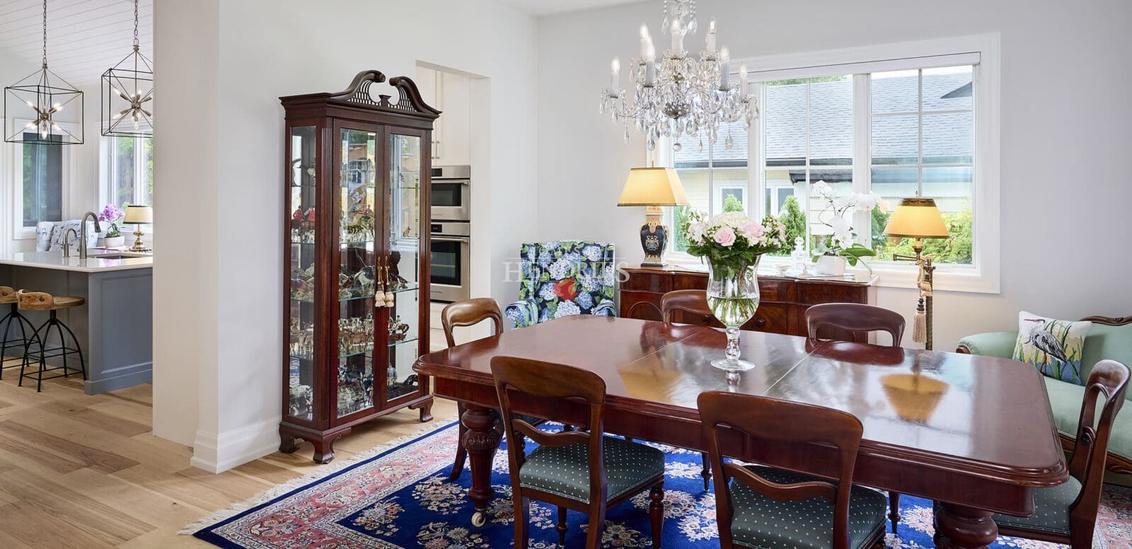 Interior view of a Victorian-inspired dining room featuring an elegant crystal chandelier, intricate moldings, and rich furnishings, creating a luxurious and timeless atmosphere.