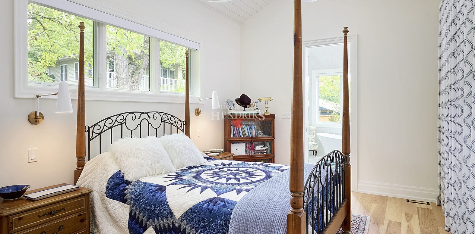 Interior view of a guest bedroom showcasing shiplap ceilings and hardwood flooring, creating a cozy and inviting atmosphere.