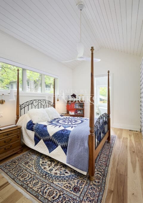 Interior view of a guest bedroom showcasing shiplap ceilings and hardwood flooring, creating a cozy and inviting atmosphere.