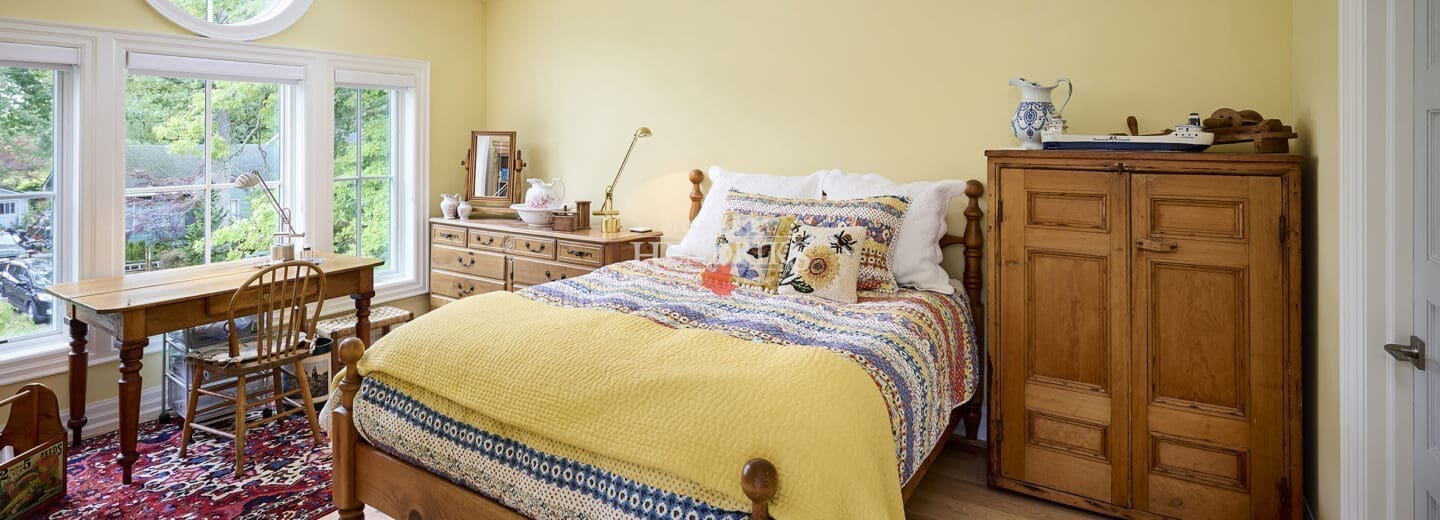 Interior view of a guest bedroom featuring a unique barreled dormer that adds architectural interest, along with cozy furnishings and inviting decor.