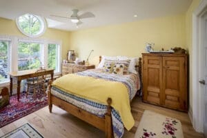 Interior view of a guest bedroom featuring a unique barreled dormer that adds architectural interest, along with cozy furnishings and inviting decor.
