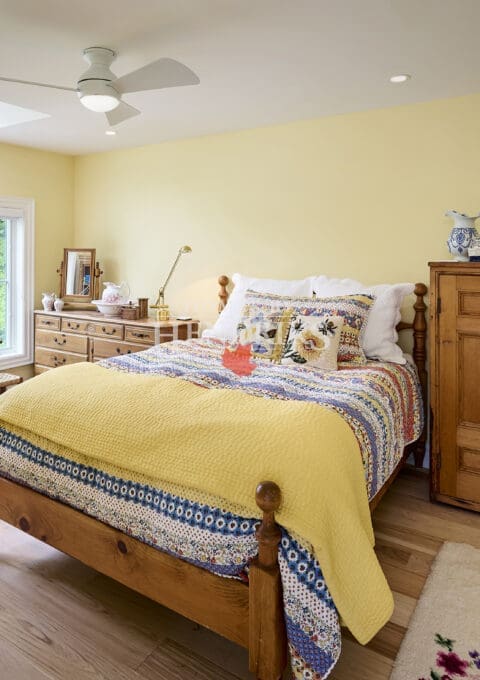 Interior view of a guest bedroom featuring a unique barreled dormer that adds architectural interest, along with cozy furnishings and inviting decor.