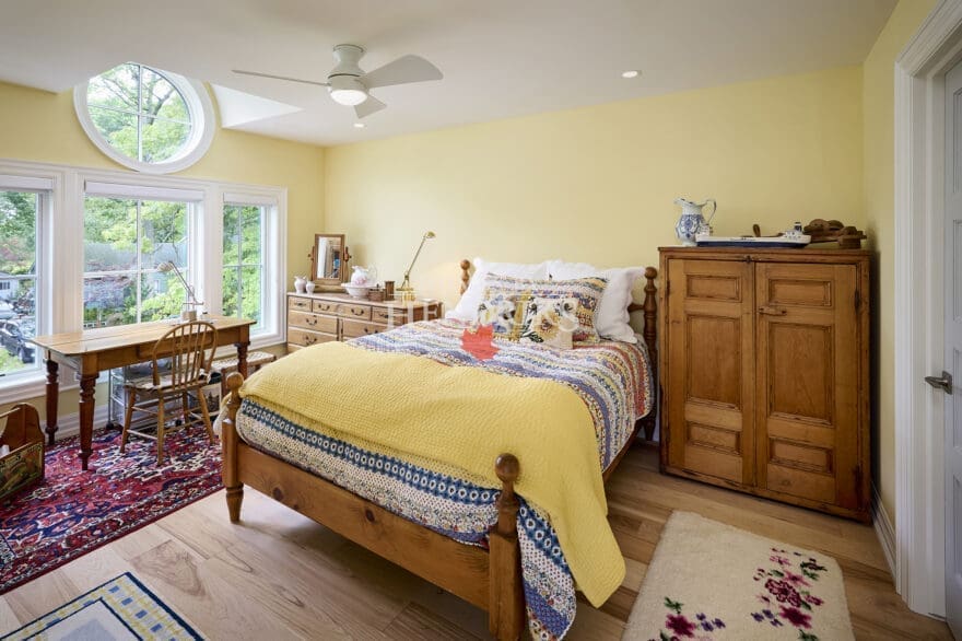 Interior view of a guest bedroom featuring a unique barreled dormer that adds architectural interest, along with cozy furnishings and inviting decor.