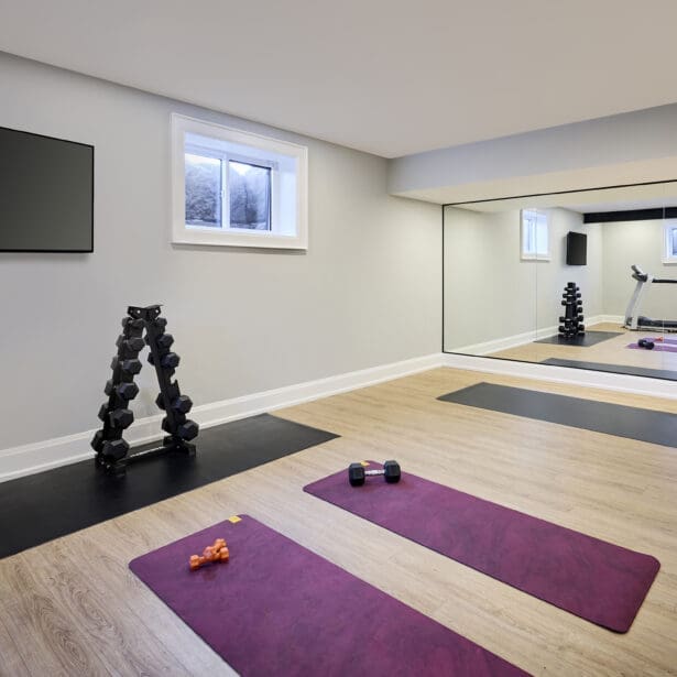 Home gym with rubber flooring and space for cardio and strength equipment.