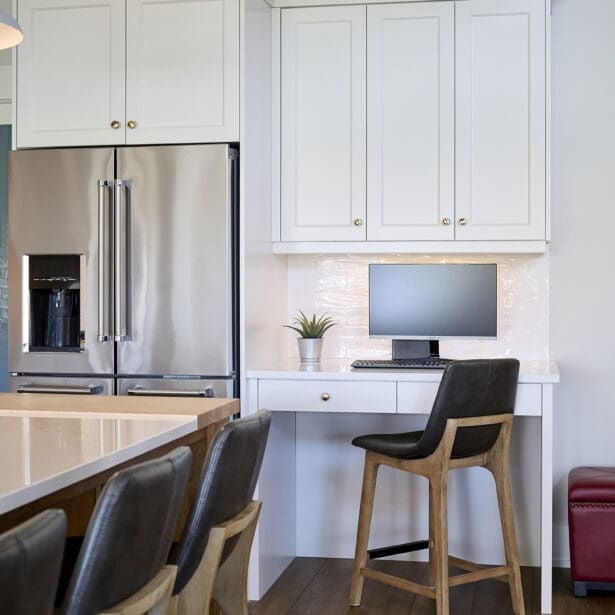 A functional kitchen work nook featuring custom cabinetry and a spacious countertop, perfect for office tasks.