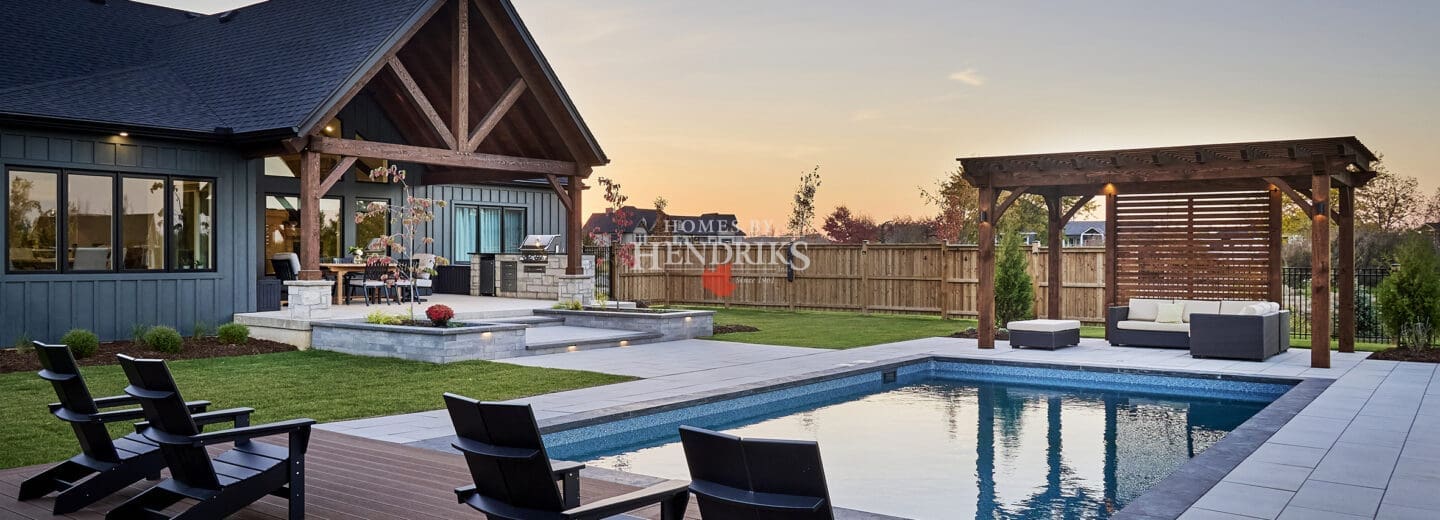 A sparkling, well-designed pool surrounded by a spacious patio and lush landscaping, offering a serene outdoor retreat.