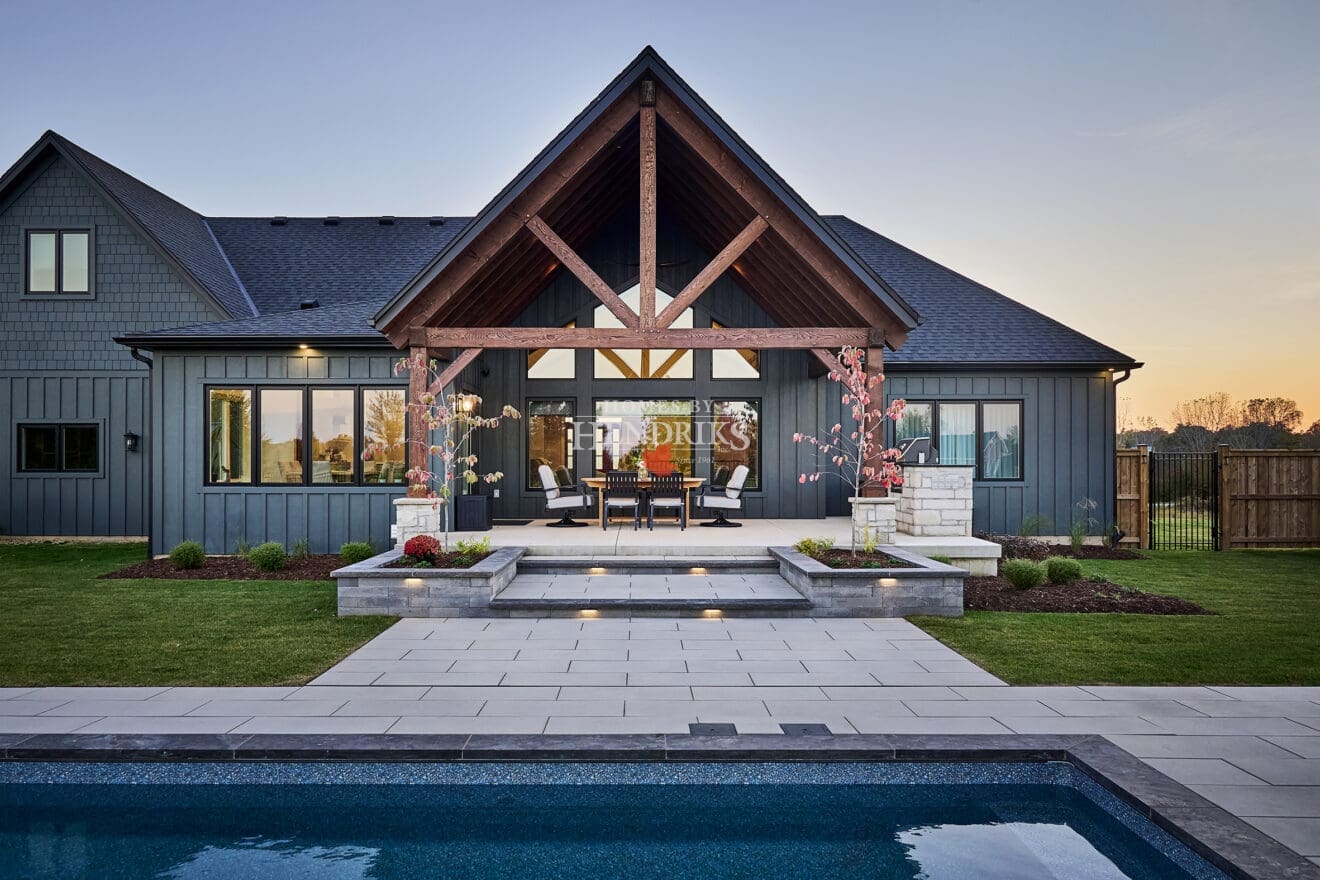 A spacious rear patio featuring a mix of natural stone and rustic timber accents, providing a perfect space for outdoor dining and relaxation.