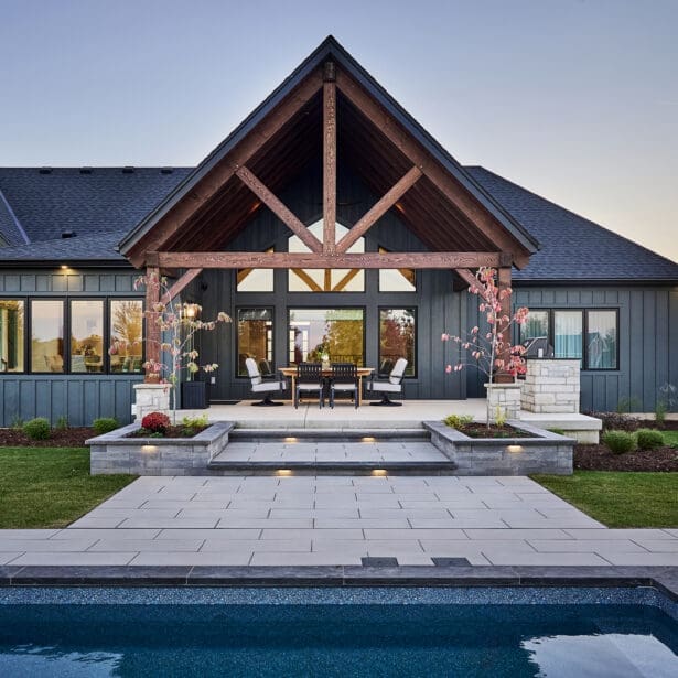 A spacious rear patio featuring a mix of natural stone and rustic timber accents, providing a perfect space for outdoor dining and relaxation.