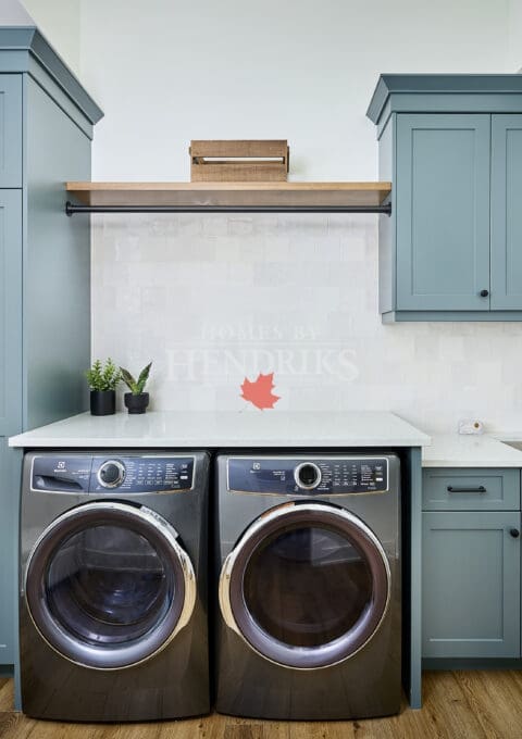 A modern laundry room featuring sleek gray cabinetry, offering ample storage space for organization.