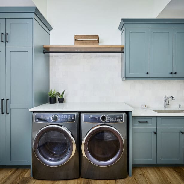 A modern laundry room featuring sleek gray cabinetry, offering ample storage space for organization.