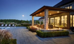 Impressive custom home with a stone exterior, limestone accents, and a beautifully landscaped yard with a sparkling pool.