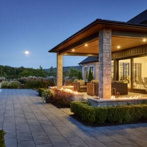 Impressive custom home with a stone exterior, limestone accents, and a beautifully landscaped yard with a sparkling pool.