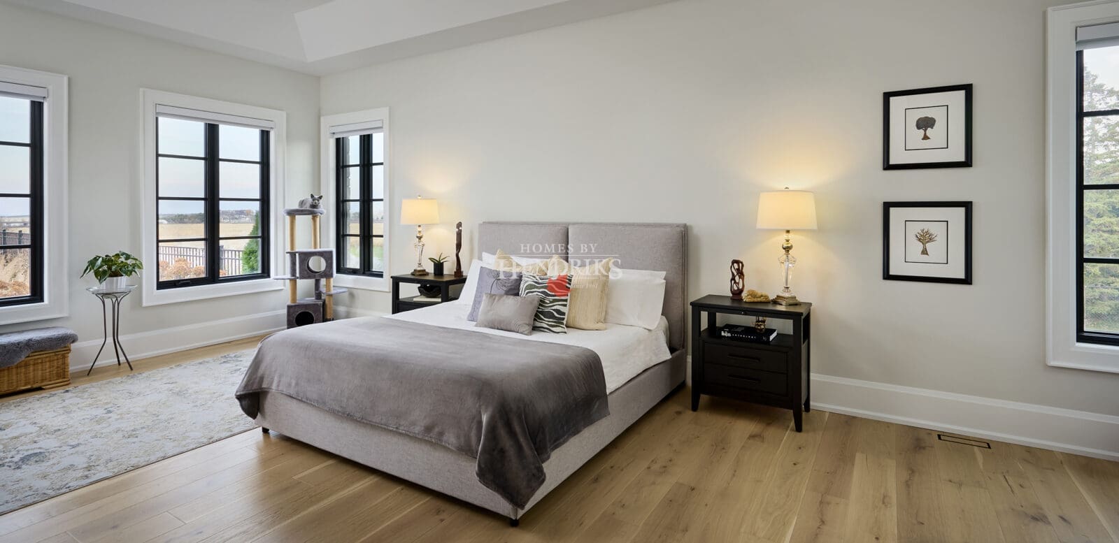 Primary bedroom with large windows, soft furnishings, and a calm, inviting atmosphere.