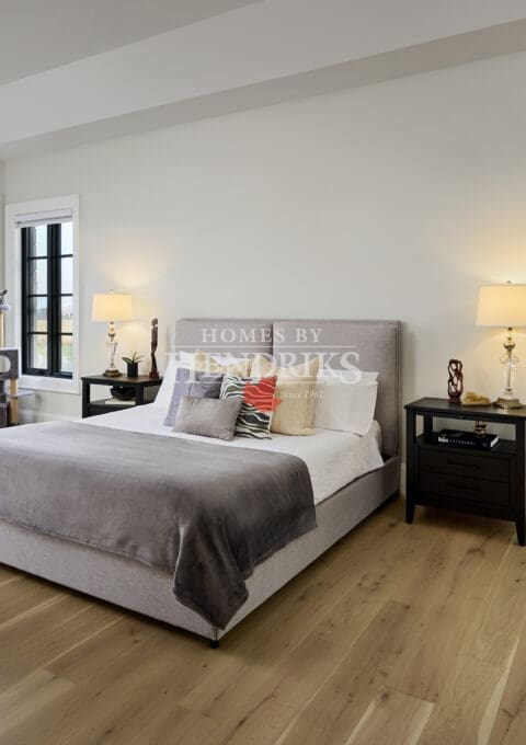 Primary bedroom with large windows, soft furnishings, and a calm, inviting atmosphere.