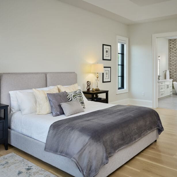 Primary bedroom with a large window wall, upholstered bed, and serene décor.