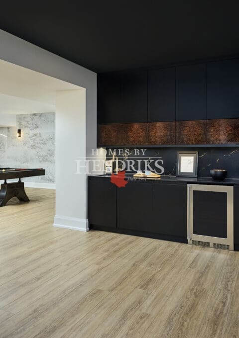 Basement bar area with stone or wood accents, built-in storage, and under-counter appliances.