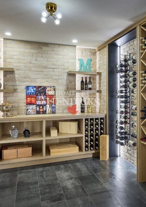 Detailed view of wine racks and bottle display inside the glass-enclosed wine room.