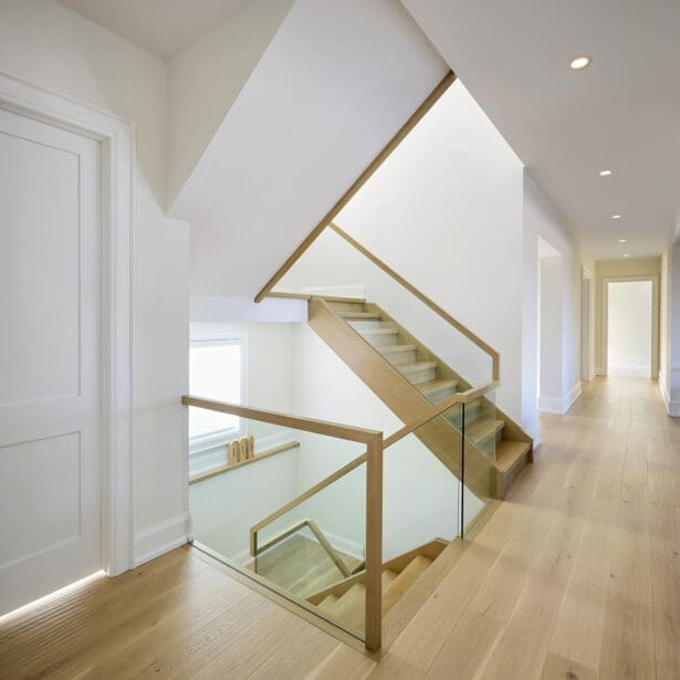 Open hallway with smooth transitions between living spaces and consistent flooring.