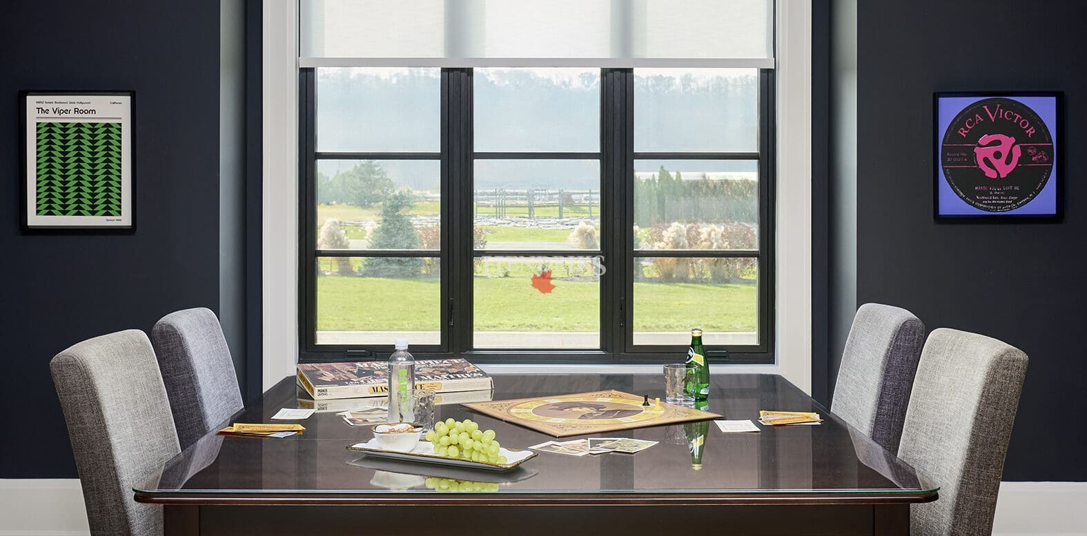 Formal dining room with a large table, modern chandelier, and expansive windows.