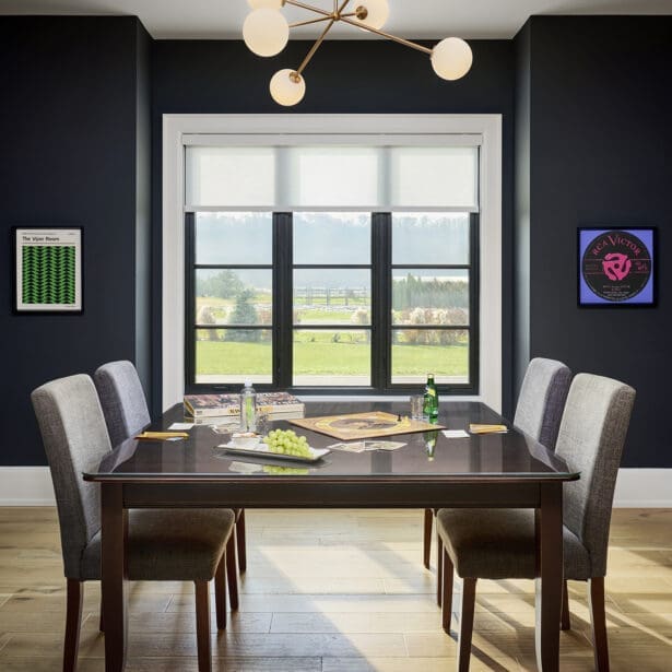 Formal dining room with a large table, modern chandelier, and expansive windows.