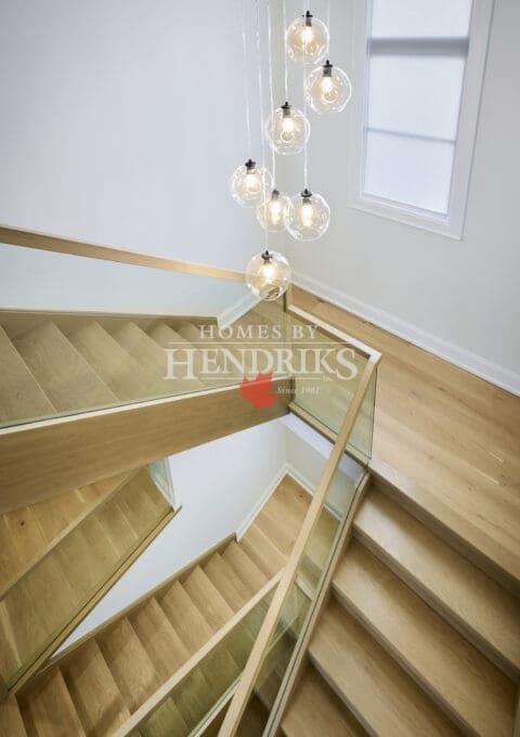 Upper-level view looking down the staircase, emphasizing the railing design and architectural lines.