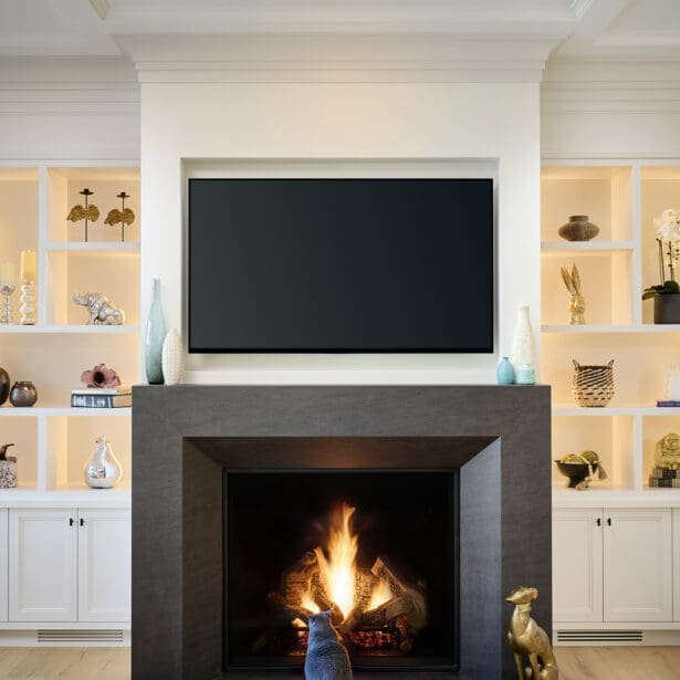 Freestanding solid-surface fireplace with a sleek linear gas insert, warm tonal cladding, and a modern minimalist design.