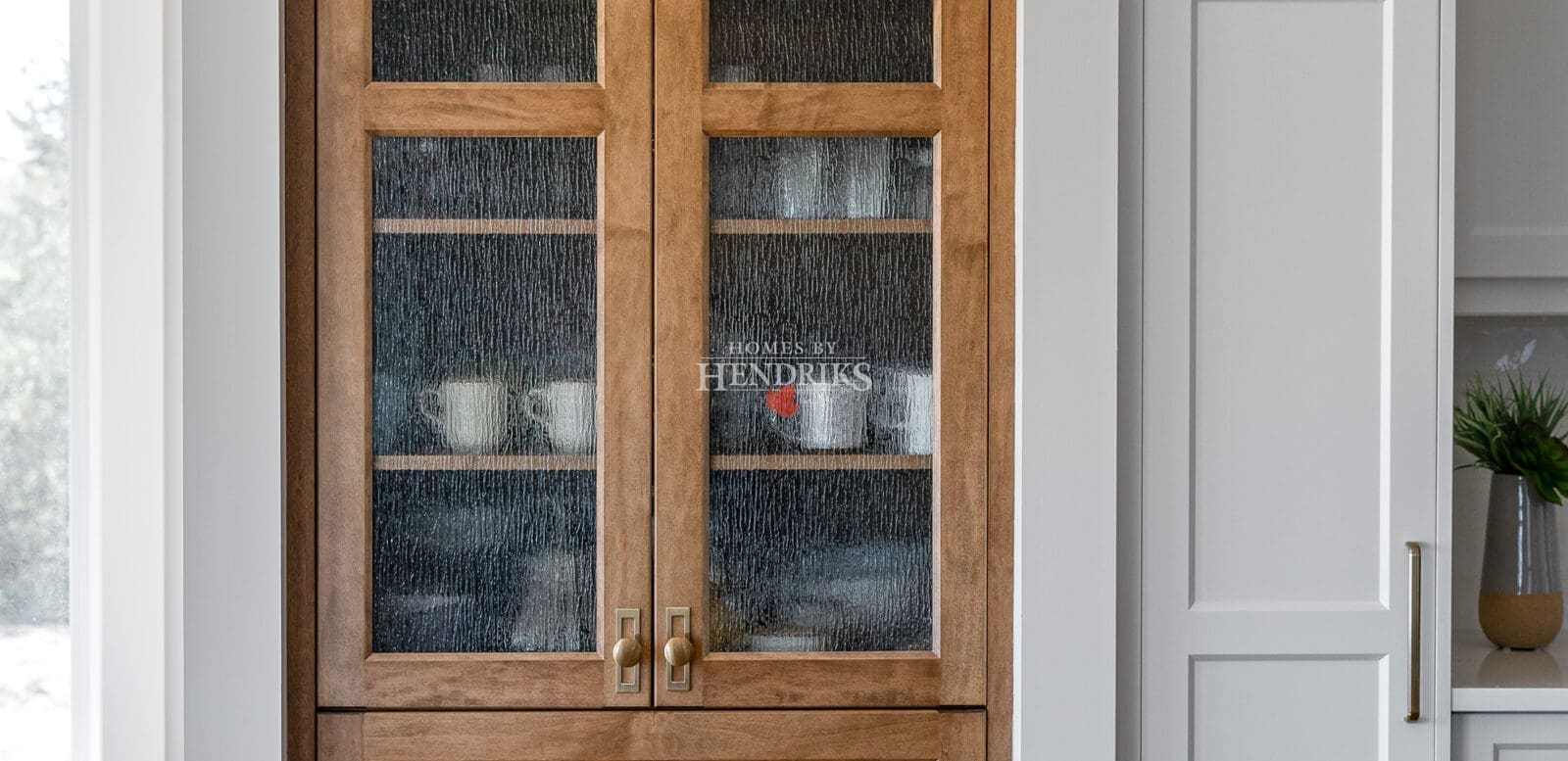 Detailed view of the custom two-tone maple cabinetry in the kitchen, highlighting the wood grain and craftsmanship.