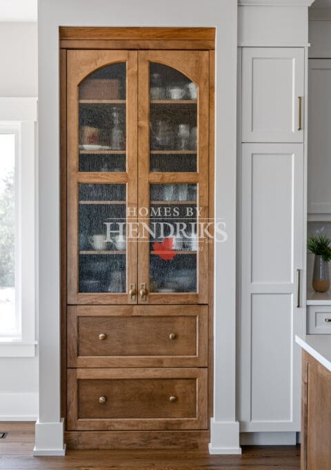 Detailed view of the custom two-tone maple cabinetry in the kitchen, highlighting the wood grain and craftsmanship.