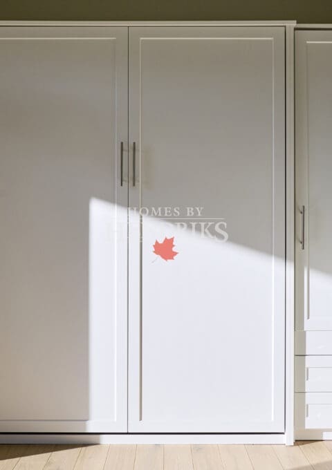 Mudroom floor-to-ceiling white cabinetry, light wood floors,