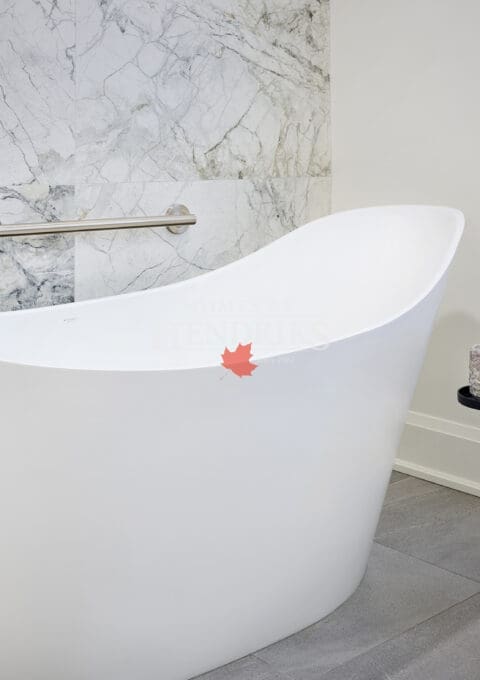 Elegant freestanding white bathtub with brushed nickel faucet, marble accent wall, and minimalist black candle stand for spa-like ambiance.