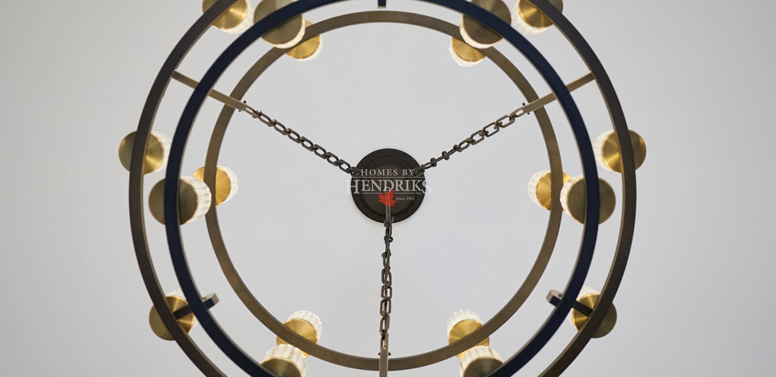 Contemporary double-ring chandelier with warm brass accents suspended from the ceiling, creating a striking modern focal point.