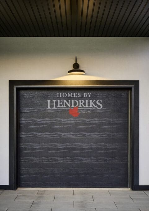 Modern black textured garage door framed in matte black trim beneath a dark paneled soffit and barn-style light fixture.