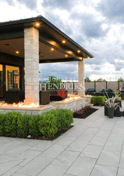 Impressive custom home with a stone exterior, limestone accents, and a beautifully landscaped yard with a sparkling pool.