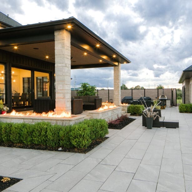 Impressive custom home with a stone exterior, limestone accents, and a beautifully landscaped yard with a sparkling pool.
