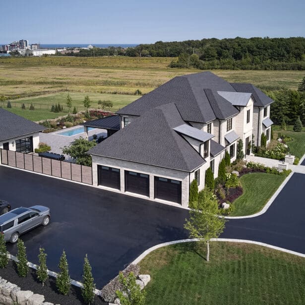 Impressive custom home with a stone exterior, limestone accents, and a beautifully landscaped yard with a sparkling pool.