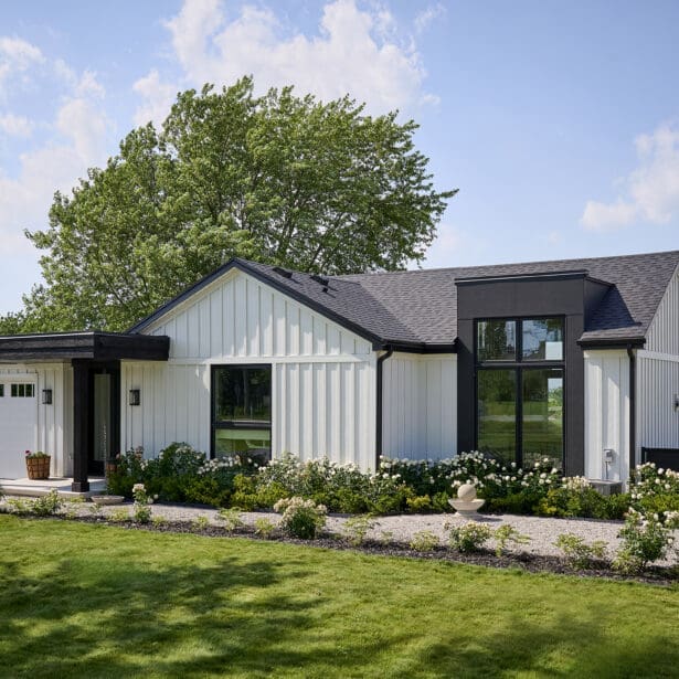Front elevation of modern white board-and-batten custom bungalow with black accents, covered entry, and attached garage.